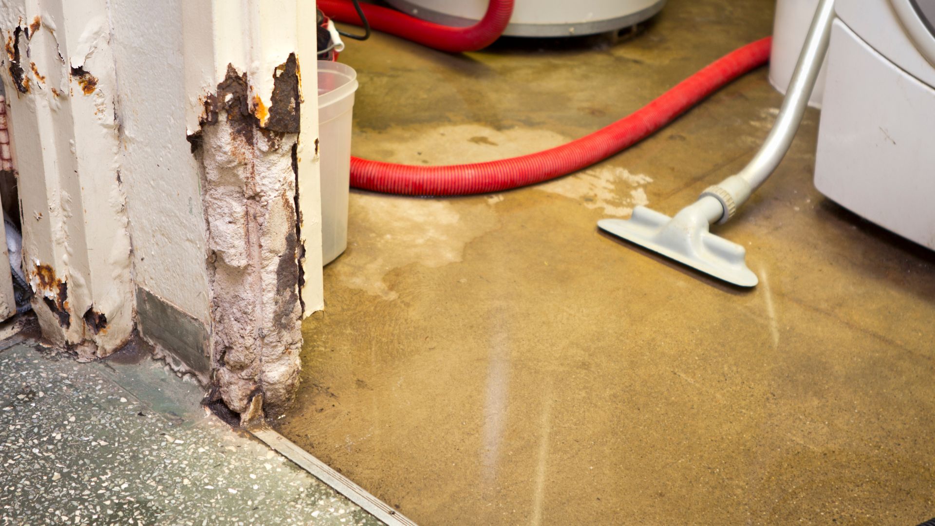 Water damage restoration with water extraction equipment removing standing water from flooded floor
